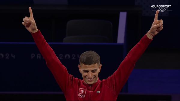 Fares Ferjani levant les bras sur le podium du Sabre à Paris 2024