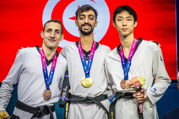 Mohamed Khalil Jendoubi (médaille d'or autour du cou) pose sur le podium avec les deux médaillées de bronze, le jordanien Mahmoud Al-Taryreh (D) et le sud-coréen Jun Jang (G)